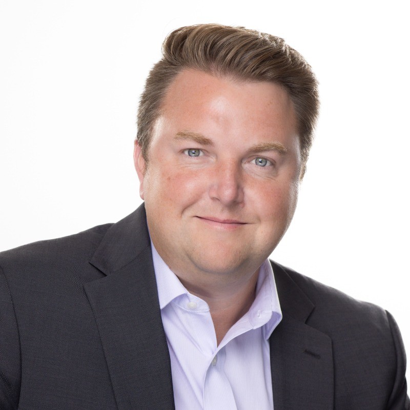 Portrait of a smiling man in a suit, a speaker at a conference.