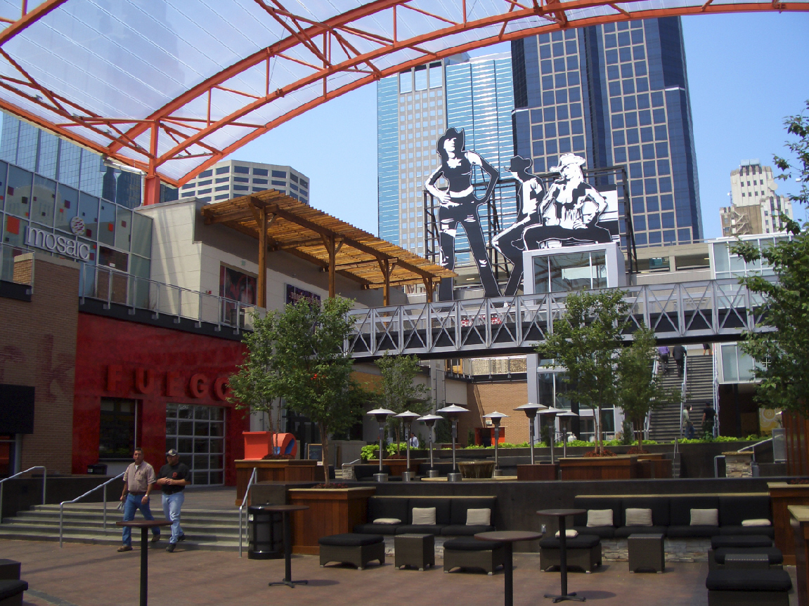 Outdoor venue with people, seating, and large art installations.